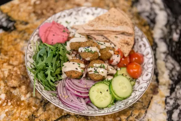 "Falafel Bowl" mit gebackenen Falafel, Zitronen-Tahini Dressing, rote Beete Hummus, Zaziki, Oliven, und Quinoa im Fit Kitchen in Barcelona, Spanien