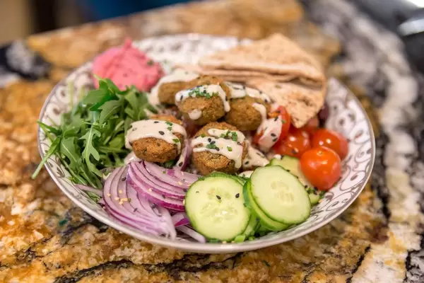 "Falafel Bowl" with baked falafel, lemon-tahini dressing, beetroot hummus, zaziki, Kalamata olives, and quinoa in Fit Kitchen in Barcelona, Spain