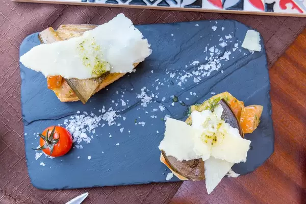 "Fusion"-Bruschetta mit Tomatenstücken, eingelegter Aubergine und Pistazien-Pesto bei Q11 in Pollença