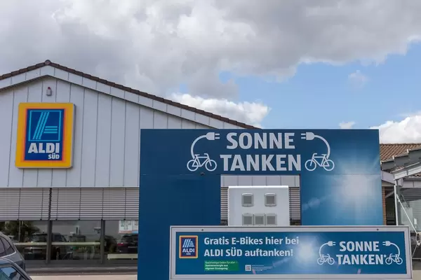 "Sonne tanken" für mehr Nachhaltigkeit: Kostenlose Elektro-Ladestation für E-Bikes auf einem Aldi-Süd Parkplatz