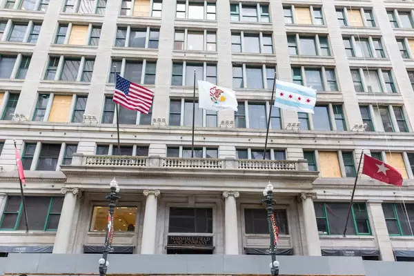 "Windige Stadt" Chicago: das Marshall Field and Company Building mit US-, Illinois- und Chicago-Fahnen, die im Wind wehen
