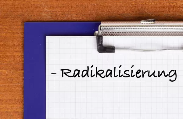 Radikalisierung als Text auf einem Klemmbrett geschrieben