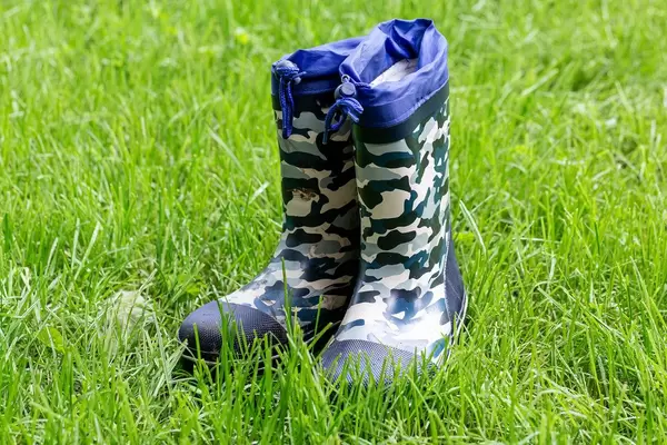 Rain boots for children on green grass
