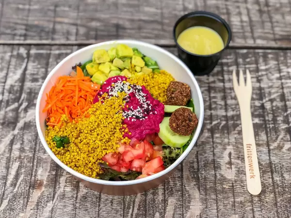 Rainbow Bowl: colorful spinach mix, avocado cubes, pink hummus, falafel, cucumber slices, quinoa, carrot stripes, tomato cubes, dressing