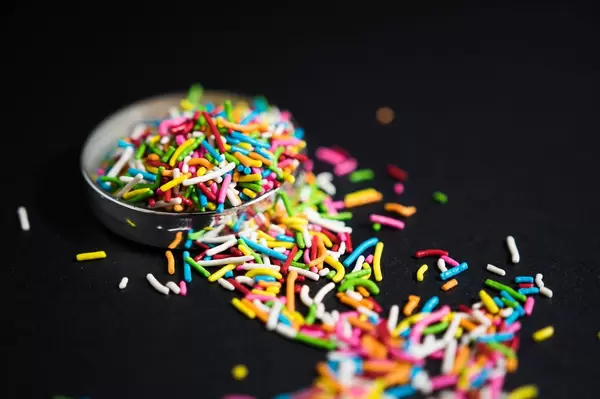 Rainbow sprinkles on a black surface