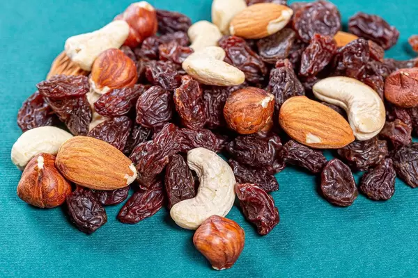 Raisins and different nuts on a green background
