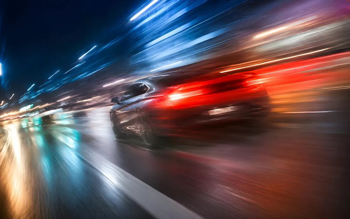 Raser bei Nacht mit Lichtspuren in der Stadt