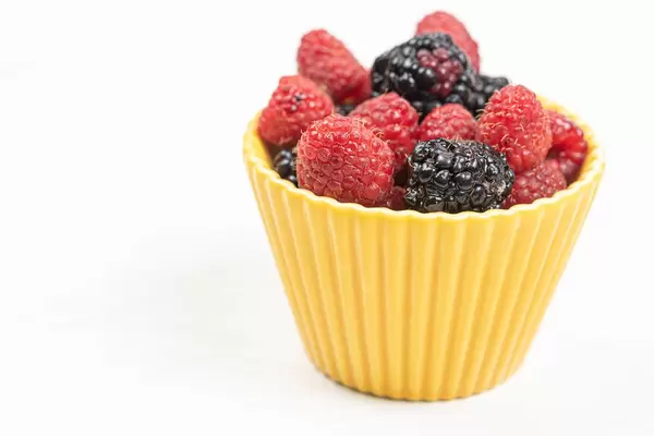 Raspberries and Blackberries in the bowl with copy space