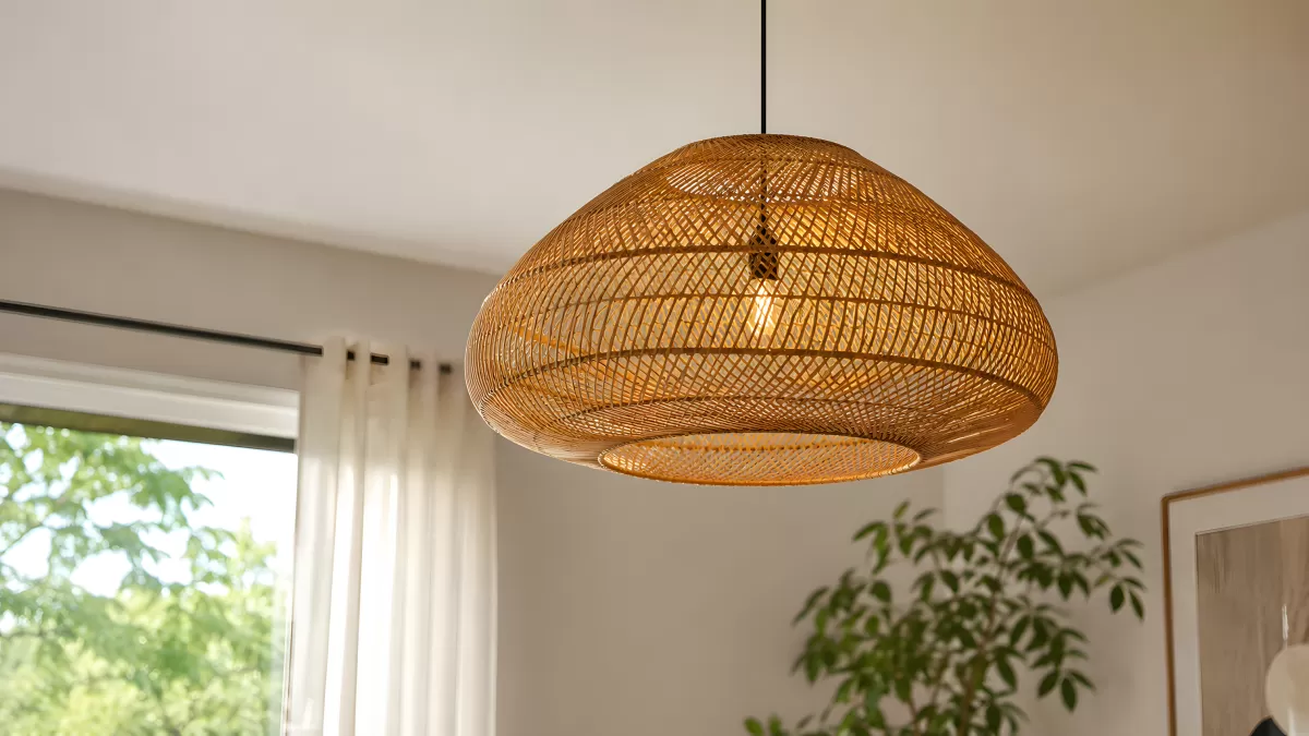 Rattan-Hängeleuchte in hellem Wohnzimmer mit Pflanzen