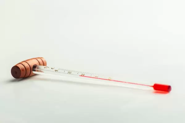 Raumthermometer mit Holzgriff vor weißem Hintergrund