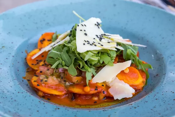 Ravioli mit Ziegenkäse und karamellisiertem Zwiebel gefüllt, mit Tomaten und Pinienkernen. Q11, Pollença