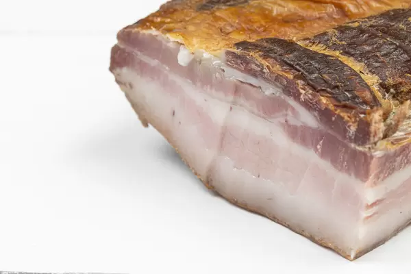 Raw Bacon on the white table with copy space