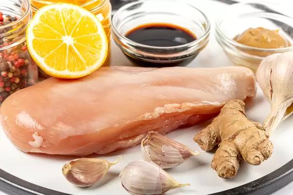 Raw chicken breast with spices, ginger, lemon and garlic