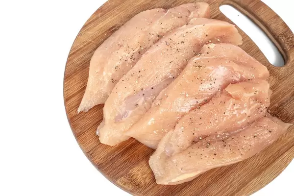 Raw Chicken Breasts with spices on the wooden board