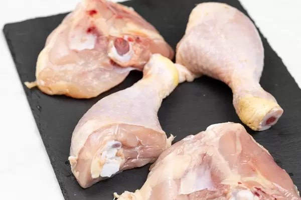 Raw Chicken Drumsticks on the black stone tray