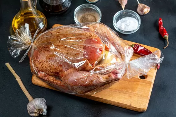 Raw chicken stuffed with apples in a sleeve for baking with spices