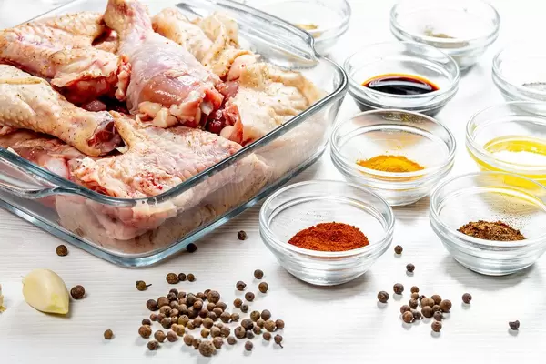 Raw chicken with spices on a white wooden table. Home cooking concept (Flip 2019)