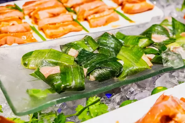 Raw chicken wrapped in leaves for grilling