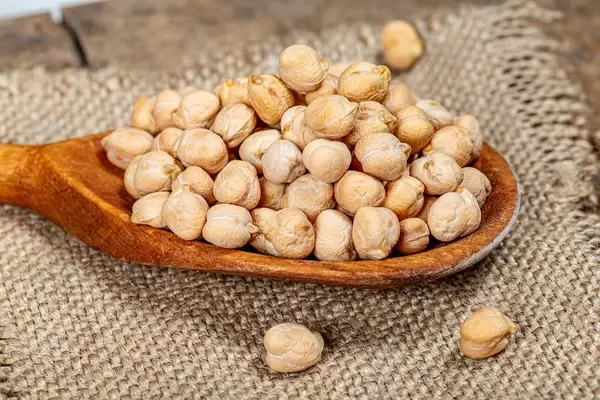 Raw chickpeas grain in a wooden spoon on burlap (Flip 2019)