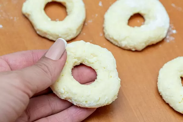 Raw dough bagel in a woman's hand
