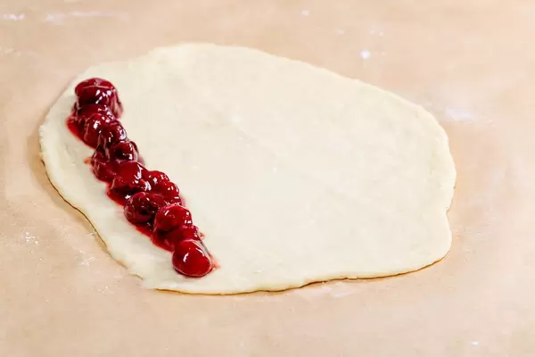 Raw dough for buns with cherry jam