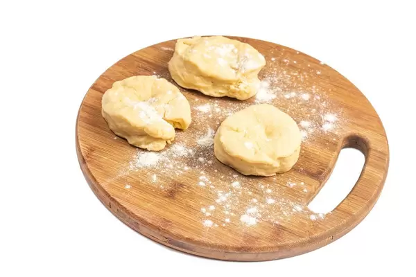 Raw Dough on the round wooden board