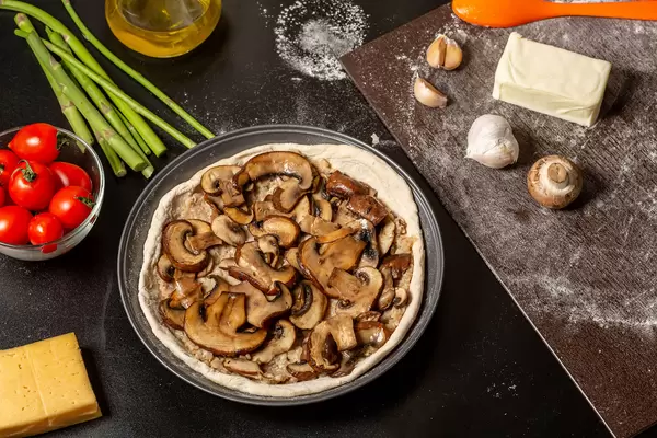 Raw dough with minced meat and fried mushrooms