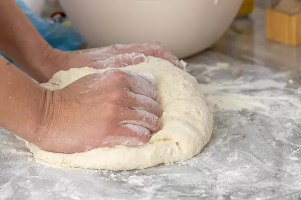 Raw Dough with womans hands on it
