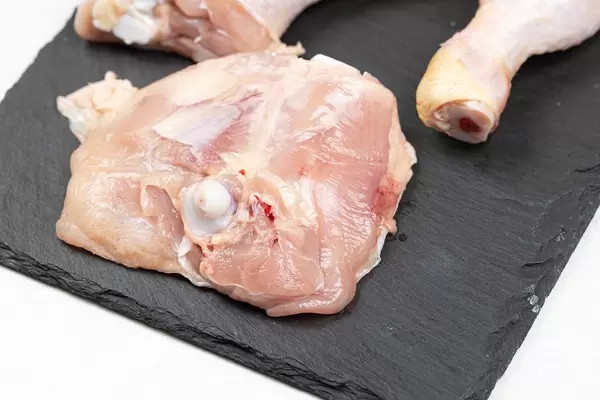 Raw Drumctisk on the black tray ready for baking