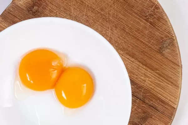 Raw Egg Yolks on the round wooden board (Flip 2019)