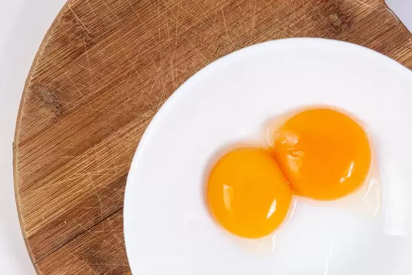 Raw Egg Yolks on the round wooden board