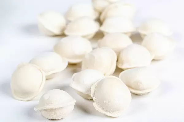 Raw frozen dumplings on a white background