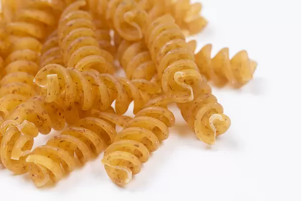 Raw Macaroni above white background