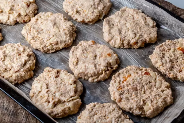 Raw oatmeal cookies on a baking sheet before baking