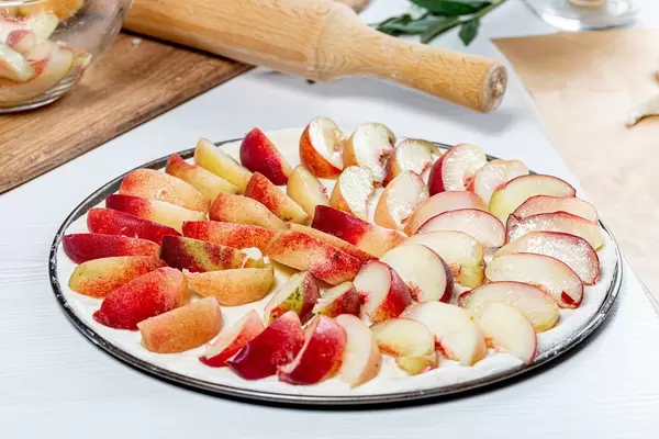 Raw open peach pie on a baking sheet (Flip 2019)