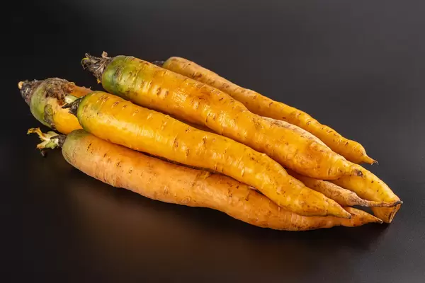 Raw organic yellow carrots on black