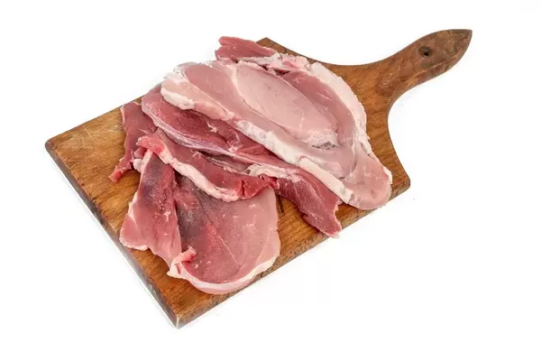 Raw Pork Chops on the wooden cutting board