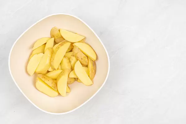 Raw Sliced Potatoes on the table with copy space