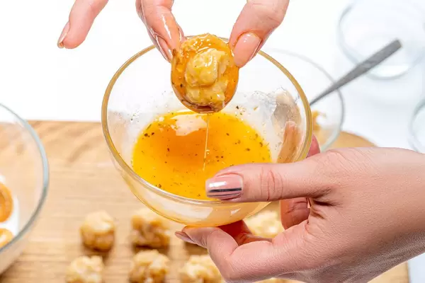 Raw stuffed bagel dipped in beaten egg with spices