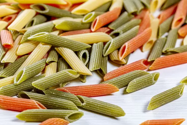 Raw tricolor pasta set on the wooden table