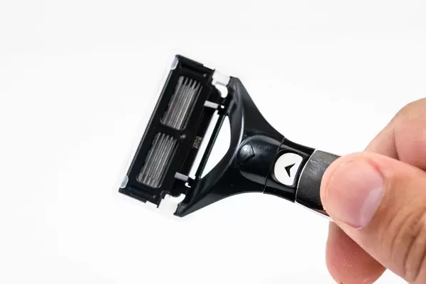 Razor Blade in the hand above white background (Flip 2019)