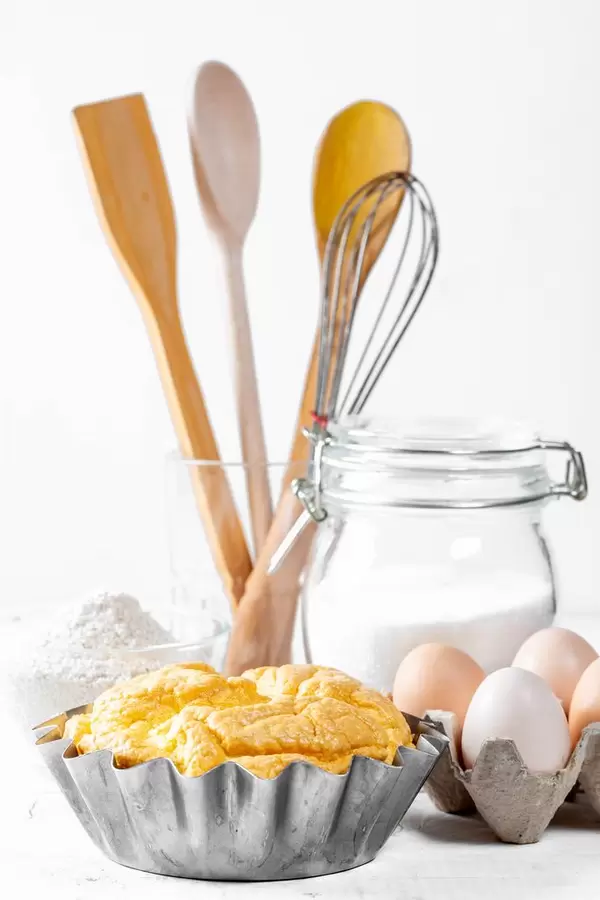 Ready hot cupcake in baking dish on white wooden table