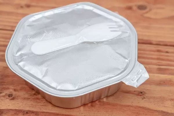 Ready Meal box with plastic fork above wooden table (Flip 2020)