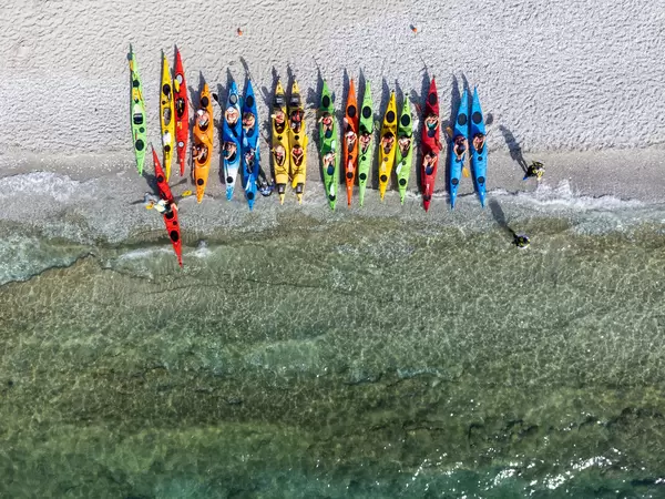 Ready to explore: tourists preparing for adventure on kayaks on the beach of Milia, Skopelos, Greece
