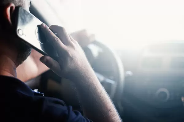 Rear view of a man talking on the phone and driving car