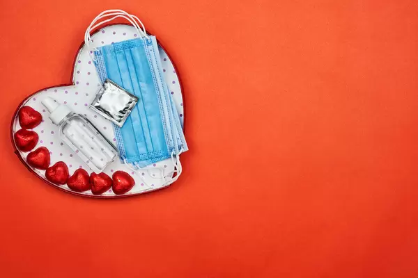 Receiving a gift in Valentine's day with face mask, hand sanitizer, sweets and condom