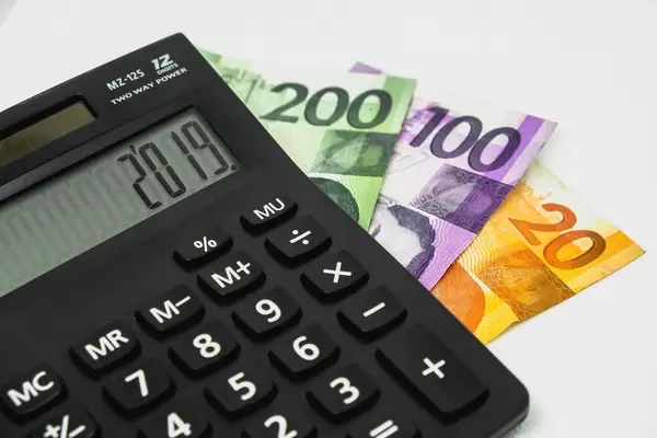 Rechner mit Peso-Rechnungen auf weißem Hintergrund