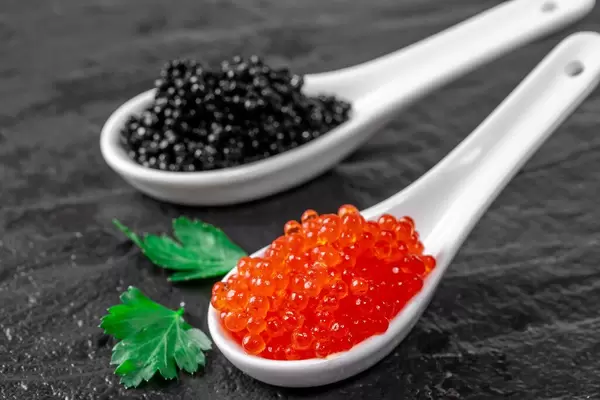 Red and black caviar on a black stone tray