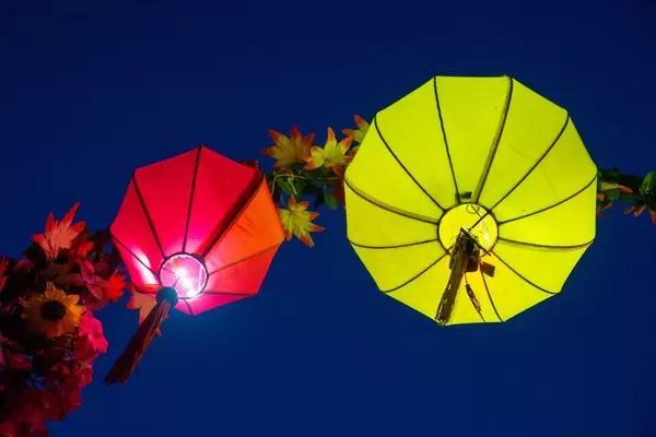 Red and Yellow Paper Lanterns in different Shapes with Bright Light on an Arch with Artificial Plants in Hoi An, Vietnam