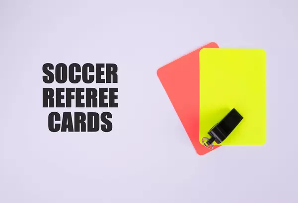 Red and yellow referee cards and a whistle for the referee and Soccer referee cards text